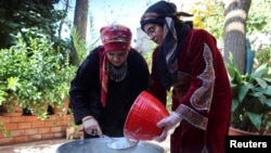 Thaera Arabiyat, pendiri inisiatif bernama 'Grandmothers Dishes by the Hands of Mothers', berdiri bersama seorang sukarelawan saat mereka menyiapkan sup tradisional di Salt, Yordania, 21 Januari 2023. (REUTERS/Jehad Shelbak)