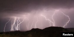 FILE - Mass lightning bolts light up night skies by Daggett airport over the high deserts, north of Barstow, California, July 1, 2015.