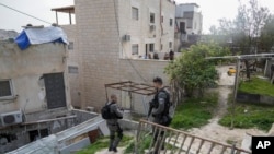 2023 年 1 月 29 日，以色列准军事边防警察站在一名巴勒斯坦枪手的家旁边，这名枪手周五在东耶路撒冷一座犹太教堂外的袭击中杀死了几人。
