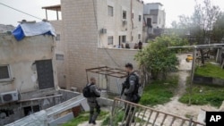 Israeli paramilitary border police stand next to the family home of a Palestinian gunman who killed several people in an attack on Friday outside a synagogue, in East Jerusalem, Jan. 29, 2023. 