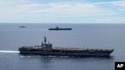 Nhóm tác chiến hàng không mẫu hạm USS Ronald Reagan (phía trước) và USS Nimitz di chuyển theo đội hình ở Biển Đông trong bức ảnh do Hải quân Hoa Kỳ cung cấp vào ngày 6/7/2020. Hoa Kỳ thường xuyên cho tàu đi qua khu vực này để thực hiện quyền quyền tự do hàng hải và hàng không.
