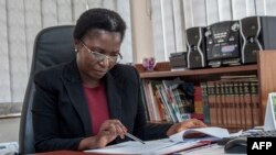 FILE - Martha Chizuma works at her desk before talking to Agence France-Presse in her office in Lilongwe, Malawi, Sept. 9, 2019.