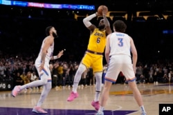 Los Angeles Lakers forward LeBron James, center, scores to pass Kareem Abdul-Jabbar to become the NBA's all-time leading scorer on Feb. 7, 2023, in Los Angeles.(AP Photo/Ashley Landis)