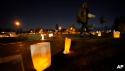 People walk past candles after the vigil for Tire Nichols, who died after being struck by Memphis police officers, in Memphis, Tenn., Thursday, Jan. 26, 2023. (AP Photo/Gerald Herbert)