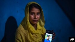 Sonali Begum, 17, displays a photo of her husband Siddique Ali, 23, who was picked up by the police, at her rented house in Guwahati, India, Saturday, Feb. 4, 2023.