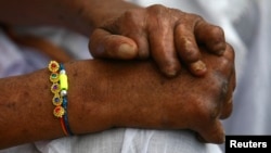 Seorang penderita kusta mengenakan "Rakhi" (benang suci) saat berlangsungnya festival Raksha Bandhan di Kushat Aashram, rumah bagi orang yang terkena kusta, di kota Chandigarh, India utara, 5 Agustus 2009. (REUTERS/Ajay Verma)