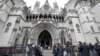 FILE - Media wait outside the High Court in London, on March 18, 2021. 