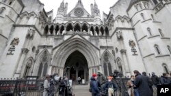 FILE - Media wait outside the High Court in London, on March 18, 2021. 