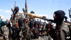 FILE - Armed al-Shabab fighters ride on pickup trucks as they prepare to travel into the city, just outside the capital Mogadishu, in Somalia on Dec. 8, 2008.