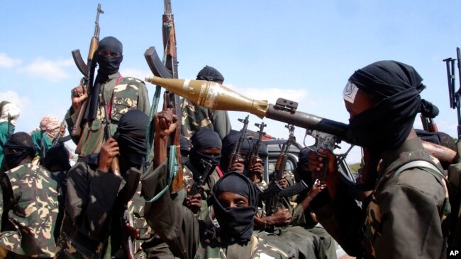 FILE - Armed al-Shabab fighters ride on pickup trucks as they prepare to travel into the city, just outside the capital Mogadishu, in Somalia on Dec. 8, 2008.