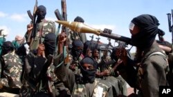 FILE - Armed al-Shabab fighters ride on pickup trucks as they prepare to travel into the city, just outside the capital Mogadishu, in Somalia on Dec. 8, 2008.