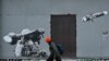 Фото для ілюстрації: хлопець в Києві проїздить повз графіті, де зображено українського військового, який стріляє з "Джавеліна", 25 січня 2023 року (Photo by Sergei SUPINSKY / AFP)