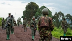 FILE - Congolese M23 rebels are seen withdrawing from an area in Kibumba, near Goma, North Kivu province of the Democratic Republic of Congo, Dec. 23, 2022. Congolese President Felix Tshisekedi said Jan. 17, 2023, that the group is faking a pullback of its forces. 