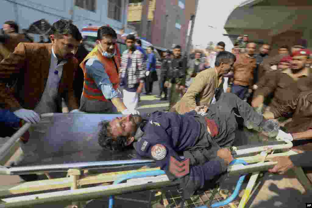 Workers and volunteers carry an injured victim of a suicide bombing upon arrival at a hospital in Peshawar, Pakistan.&nbsp;A powerful bomb blast ripped through a packed mosque in Peshawar, killing at least 47 worshipers and injuring at least 140 others. (AP Photo/Muhammad Sajjad)