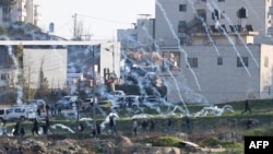 Pasukan Israel menembakan gas air mata untuk membubarkan demonstran asal Palestina yang memprotes pendudukan wilayah Tepi Barat dalam aksi di Kota Ramallah, Tepi Barat, pada 26 Januari 2023. (Foto: AFP/Ahmad Gharabli)