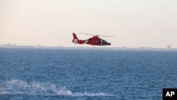 Një helikopter i Rojës Bregdetare të Shteteve të Bashkuara përshkon zonën ku u rrëzua balona kineze