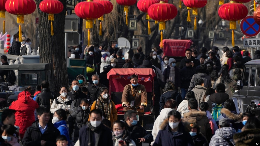 2023年1月30日，中国放弃了对新冠病毒的“零容忍”政策后，北京后海一条熙熙攘攘的街道，传统的三轮儿在人群中穿行。(美联社）