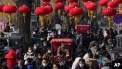 Seorang pengendara becak sedang melewati jalan yang padat di Danau Houhai, di Beijing, 30 Januari 2023. Perekonomian China diperkirakan akan pulih, tumbuh 5.3% pada tahun ini menurut jajak pendapat kantor berita AFP. (Foto: Andy Wong/AP Photo)