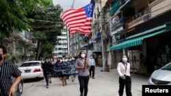 FILE - People march with the federal flag as they support National Unity Government (NUG) in Yangon, Myanmar, April 18, 2021.