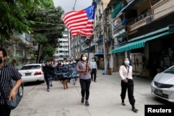 FILE - People march with the federal flag as they support National Unity Government (NUG) in Yangon, Myanmar, April 18, 2021.