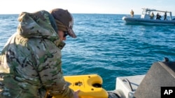 Sailors assigned to an ordnance disposal group prepare an underwater vehicle to search for debris from a Chinese high-altitude balloon off the coast of Myrtle Beach, S.C., Feb. 7, 2023. (Ryan Seelbach/U.S. Navy via AP)