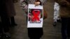 A woman holds a photograph of far-right activist Rasmus Paludan during a small protest outside the Swedish consulate in Istanbul, Turkey, Saturday, Jan. 28, 2023. 