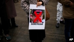A woman holds a photograph of far-right activist Rasmus Paludan during a small protest outside the Swedish consulate in Istanbul, Turkey, Saturday, Jan. 28, 2023. 