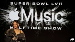 Rihanna poses for a photo after a halftime show news conference ahead of the Super Bowl 57 NFL football game, Feb. 9, 2023, in Phoenix.