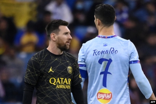 Penyerang Paris Saint-Germain Argentina Lionel Messi (kiri) berjalan melewati penyerang Portugal All-Star Riyadh Cristiano Ronaldo (kanan) selama pertandingan sepak bola Piala Musim Riyadh antara Riyadh All-Stars dan Paris Saint-Germain di Stadion King Fahd di Riyadh pada 19 Januari 2023. (Foto: AFP)