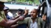 Police arrests Moses Sserugga, a member of 'Torture Survivors Movement Uganda' at the headquarters of Uganda Human Rights Commission during a protest calling for the resignation of the the commission chairperson Mariam Wangadya, in Kampala, Feb. 9, 2023. 