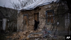 Oleksandra Hryhoryna inspects her house, which was damaged by shelling last fall in Kalynivske, Ukraine, Jan. 28, 2023.