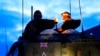 Britain's military officers sit on top of an armored vehicle at the Tapa Military Camp, in Estonia, Jan. 19, 2023. 