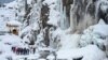 Para turis mengunjungi air terjun beku di daerah Drang di Tangmarh, Kashmir yang dikuasai India. (AFP)&nbsp;