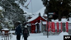 Sejumlah orang berjalan di atas salju ketika mengunjungi Kuil Zenkoji di Nagano, Jepang, pada 25 Januari 2023. (Foto: AFP/Kazuhiro Nogi)