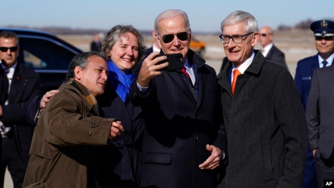 President Joe Biden takes a photo with Gov. Tony Evers, D-Wis., right, after arriving at Truax Field Air National Guard Base, Feb. 8, 2023, in Madison, Wis. Biden was in Wisconsin to promote his economic agenda.