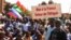 A protester holds a sign that reads, 'No to France the thief of Africa' as people gather to show their support to Burkina Faso's new military leader Ibrahim Traore, in Ouagadougou, Burkina Faso, Jan. 20, 2023. 
