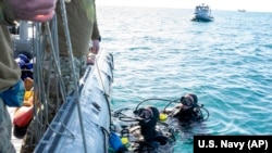 美国海军提供的照片显示美军潜水员在南卡罗莱纳州海岸外打捞被击落的中国间谍气球碎片。（2023年2月7日）