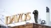 A police officer stands on the roof of a hotel and monitor the area with a binocular in Davos, Switzerland, Jan. 16, 2023. 