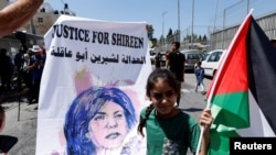 Seorang anak Palestina tampak membawa poster wartawan Shireen Abu Akleh dalam aksi protes menuntut keadilan terhadap kematian sang wartawan di Yerusalem, pada 15 Juli 2022. (Foto: Reuters/Ammar Awad)