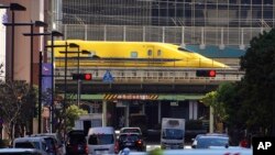 Shinkansen high-speed test trains or known as Doctor Yellow, travels along an overpass in the middle of downtown in Tokyo, Japan.