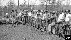 Members of the Civilian Conservation Corps, a New Deal program that provided jobs to unemployed, unmarried men ages 18–25, get ready to do forestry work near Luray, Virginia, April 18, 1933.