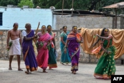 FILE - A former 'devadasi' woman, front, dances while other devotees sing before visiting Yellamma Devi temple in Savadatti of Belgaum district, in India's Karnataka state, Sept. 21, 2022.