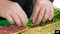 Chef Josh Gjersand menyiapkan sandwich dengan pesto aioli buatan sendiri dan dilapisi dengan salami Toscano, Monterey Jack, dan arugula segar untuk siswa SMA Mount Diablo di Concord, California, Jumat, 13 Januari 2023. (AP/Godofredo A.Vásquez)