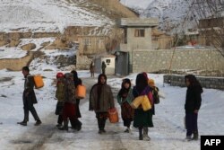 Anak-anak membawa wadah untuk mengambil air minum pada musim dingin di distrik Yaftal Sufla, Provinsi Badakhshan, 18 Januari 2023. (OMER ABRAR/AFP)