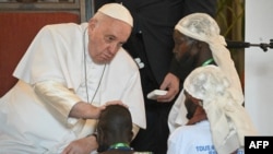 Papa Francis (kushoto) akimbariki mtoto alipokutana na waathiriwa wa ghasia zinazoendelea mashariki mwa DRC Jan 31, 2023