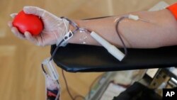 FILE - A person donates blood in Yorba Linda, California, March 31, 2020.