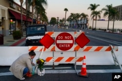 Stephanie Kozofsky, 31, leaves flowers and candles to honor the victims killed in Saturday’s ballroom dance studio shooting in Monterey Park, California, Jan. 22, 2023.