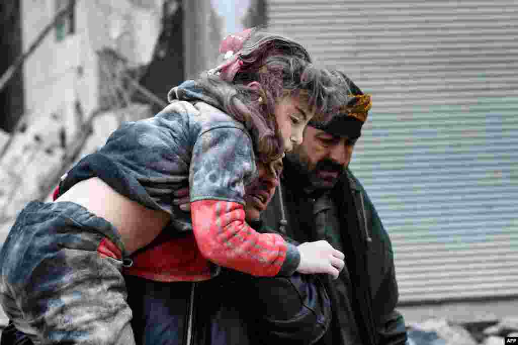 Warga membawa seorang anak yang terluka dari puing-puing bangunan yang runtuh setelah gempa bumi di Jandaris, di kawasan pedesaan kota Afrin, di provinsi Aleppo yang dikuasai pemberontak, Suriah barat laut&nbsp; 6 Februari 2023. (AFP)