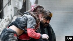 Residentes cargan a un niño herido de los escombros de un edificio derrumbado luego de un terremoto en la ciudad de Jandaris, en el campo de la ciudad de Afrin, en el noroeste de Siria, en la parte rebelde de la provincia de Alepo, el 6 de febrero de 2023.