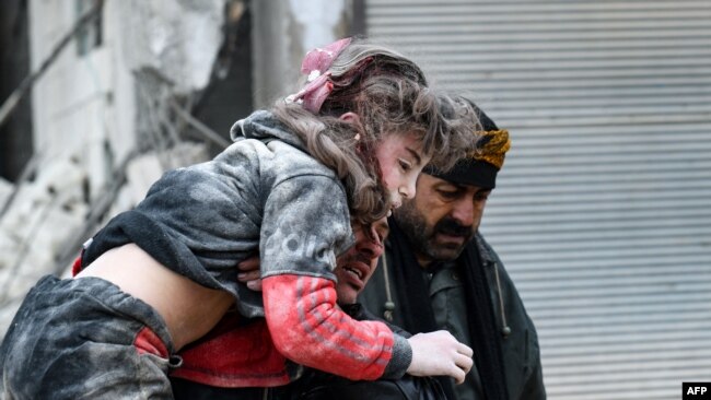 Residentes cargan a un niño herido de los escombros de un edificio derrumbado luego de un terremoto en la ciudad de Jandaris, en el campo de la ciudad de Afrin, en el noroeste de Siria, en la parte rebelde de la provincia de Alepo, el 6 de febrero de 2023.